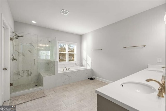 full bath with a garden tub, a sink, visible vents, and double vanity