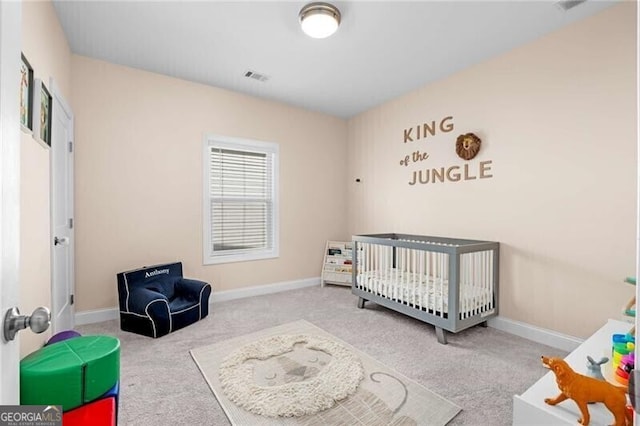 bedroom featuring light carpet, a crib, visible vents, and baseboards