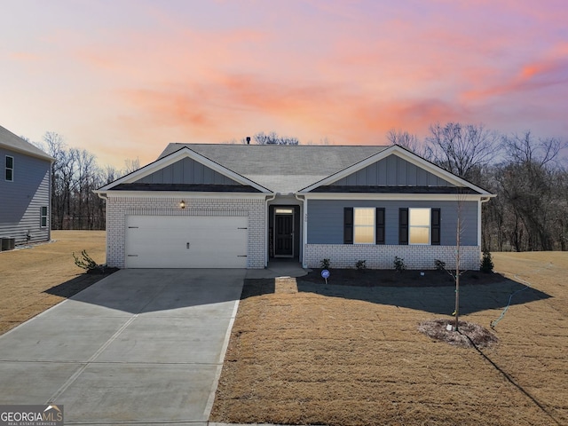 ranch-style house featuring a garage, board and batten siding, and brick siding