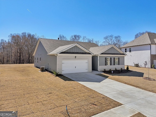 ranch-style house with concrete driveway, an attached garage, central air condition unit, board and batten siding, and brick siding