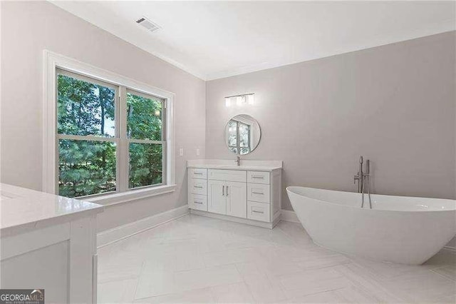 full bath featuring visible vents, a soaking tub, vanity, and baseboards