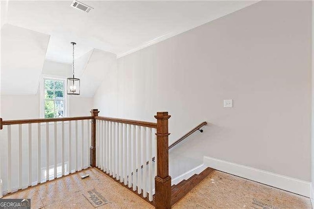 staircase featuring lofted ceiling, visible vents, a notable chandelier, and baseboards