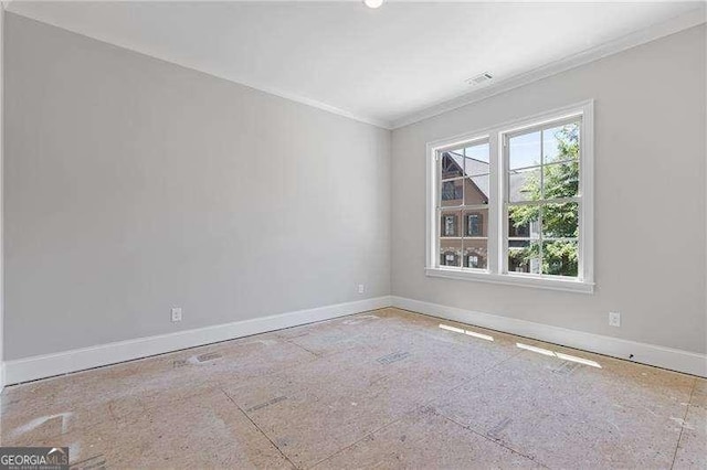 empty room featuring crown molding, visible vents, and baseboards