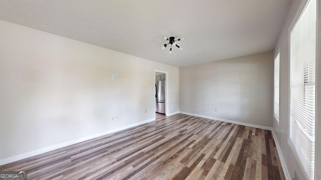 empty room featuring wood finished floors and baseboards