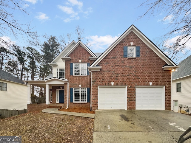 traditional-style house with a garage, concrete driveway, brick siding, and covered porch