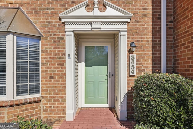 view of exterior entry with brick siding