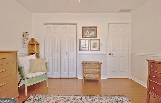 sitting room featuring wood finished floors and visible vents