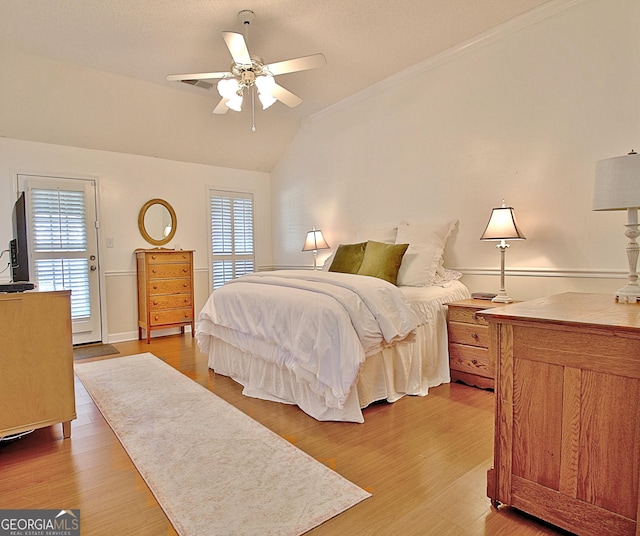 bedroom with lofted ceiling, multiple windows, a ceiling fan, and wood finished floors