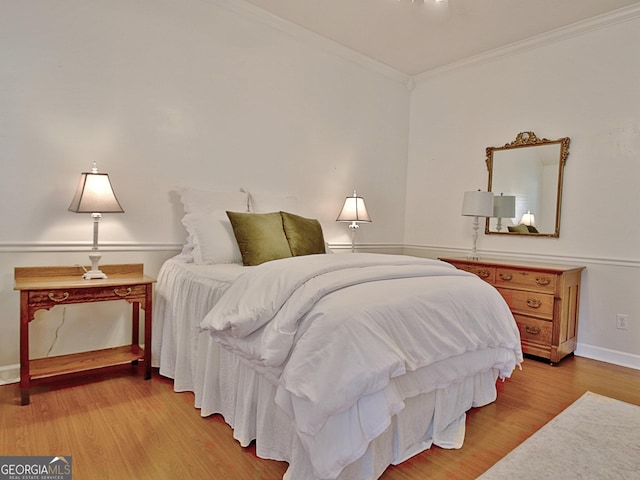 bedroom with ornamental molding, light wood-style flooring, and baseboards