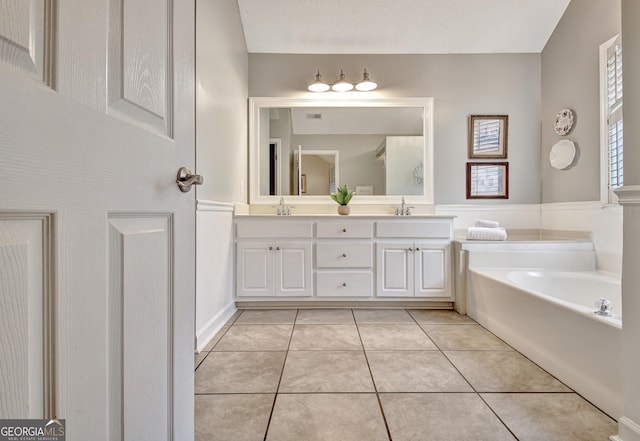 full bathroom featuring double vanity, a sink, a bath, and tile patterned floors