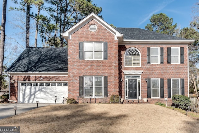 view of front facade featuring an attached garage, roof with shingles, concrete driveway, and brick siding