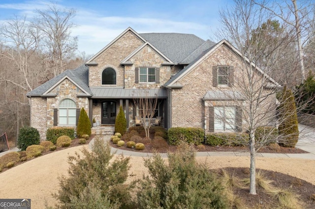 view of front of property with a porch, stone siding, and brick siding