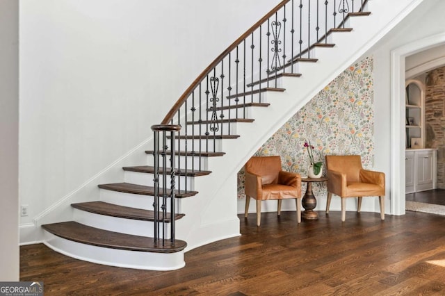 staircase featuring baseboards and wood finished floors