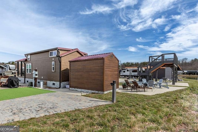 view of side of property with a patio area and a yard