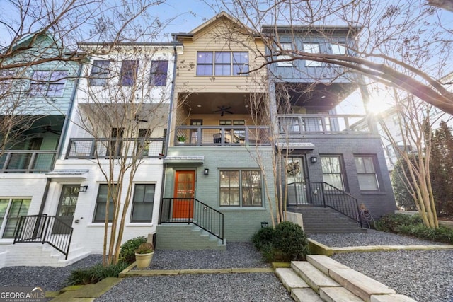 townhome / multi-family property featuring brick siding, ceiling fan, and a balcony