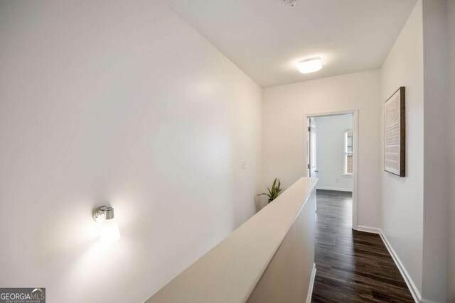 hall featuring baseboards and dark wood finished floors