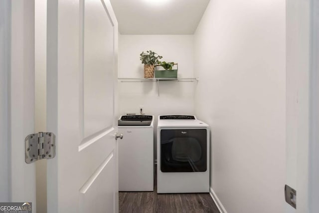 clothes washing area featuring dark wood-style flooring, separate washer and dryer, and laundry area
