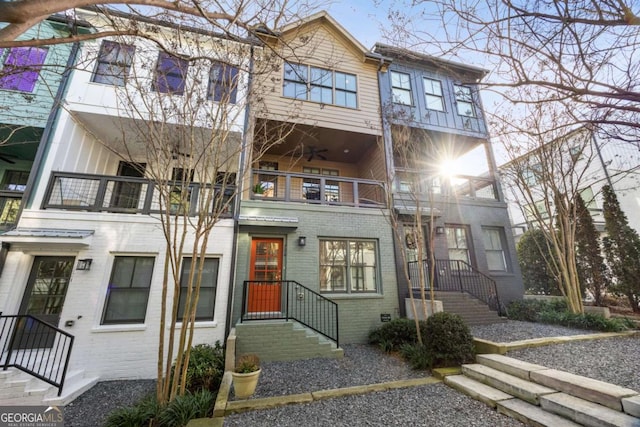 multi unit property with a balcony and brick siding
