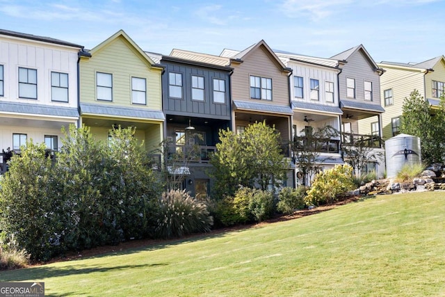 back of property featuring board and batten siding and a lawn