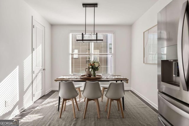 dining area featuring a notable chandelier, breakfast area, dark wood-style floors, and baseboards