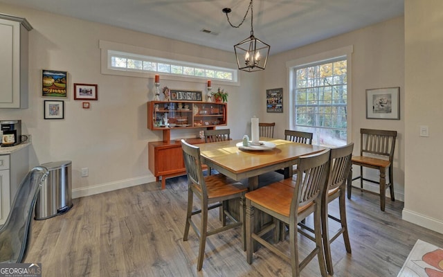 dining room with visible vents, wood finished floors, a wealth of natural light, and baseboards