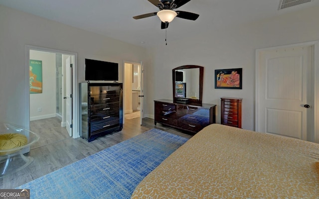 bedroom featuring baseboards, visible vents, connected bathroom, ceiling fan, and wood finished floors