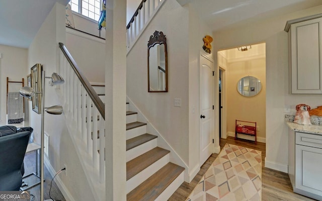 stairs featuring wood finished floors and baseboards