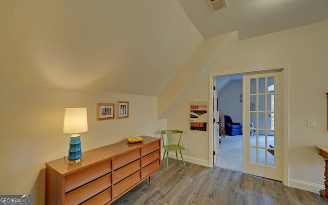 bonus room featuring visible vents, vaulted ceiling, baseboards, and wood finished floors