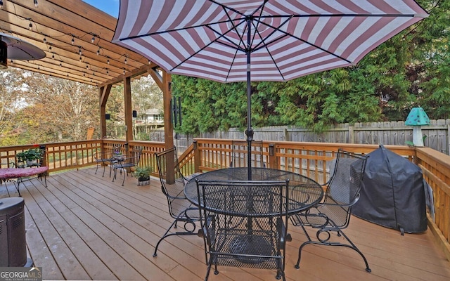 wooden terrace featuring outdoor dining area, a fenced backyard, and area for grilling