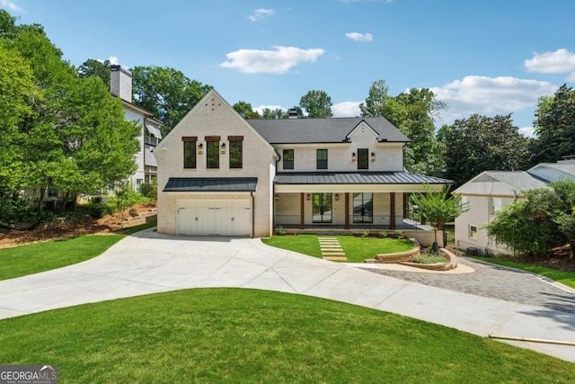 view of front of house with a garage, concrete driveway, metal roof, a standing seam roof, and a front yard