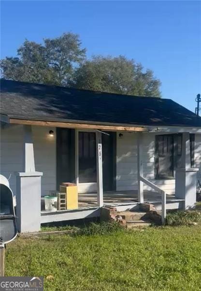 exterior space with covered porch and a lawn