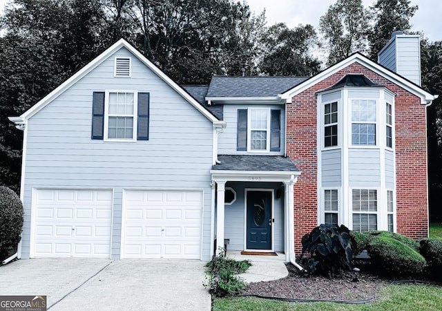 traditional-style house with a garage, concrete driveway, and brick siding