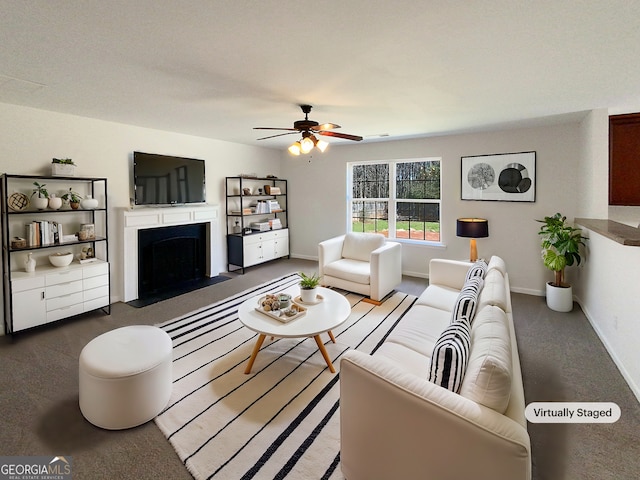 living area with a fireplace with flush hearth, baseboards, and a ceiling fan