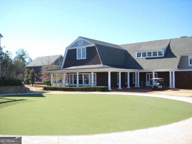view of front of house with metal roof, a standing seam roof, and a gambrel roof