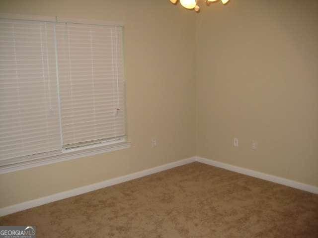 spare room with carpet flooring and baseboards
