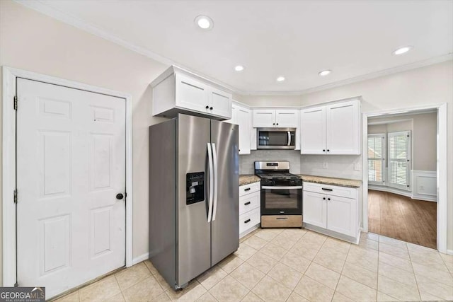 kitchen featuring light stone counters, light tile patterned flooring, white cabinets, appliances with stainless steel finishes, and crown molding