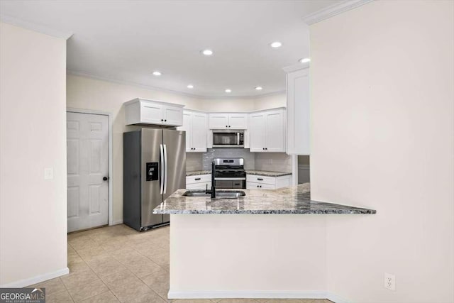 kitchen with a peninsula, appliances with stainless steel finishes, stone counters, and white cabinetry