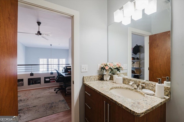 bathroom with a ceiling fan, vanity, and wood finished floors