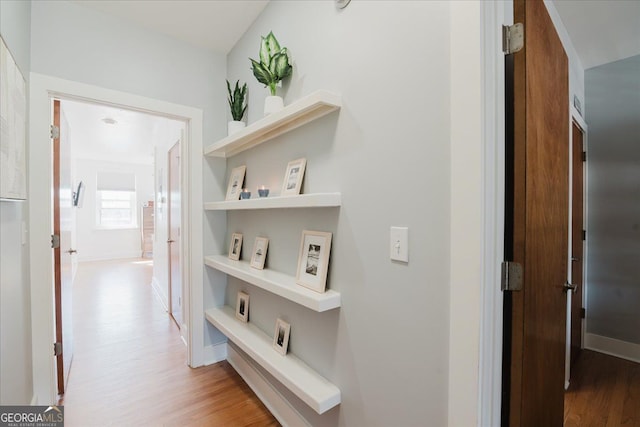 hallway with baseboards and light wood finished floors