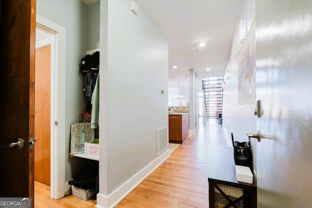 hallway featuring light wood-style flooring, visible vents, baseboards, and recessed lighting