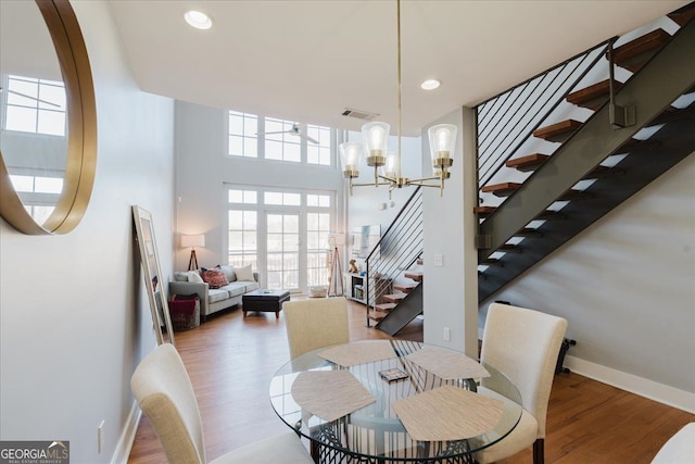 dining space with plenty of natural light, stairs, visible vents, and wood finished floors