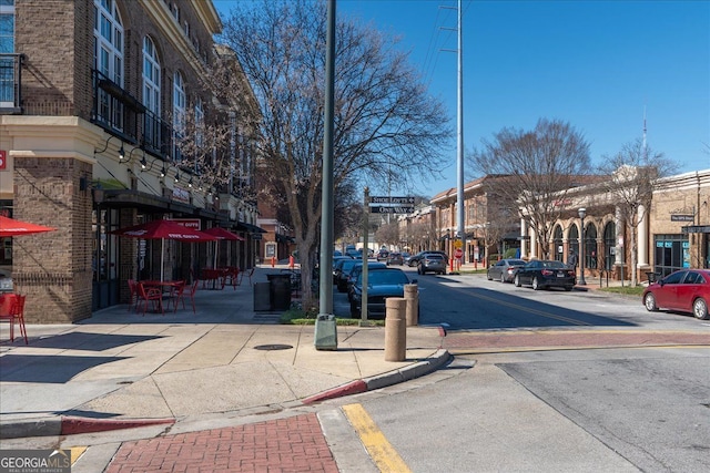 view of road featuring curbs, street lights, and sidewalks