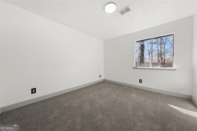 unfurnished room featuring carpet flooring, visible vents, and baseboards