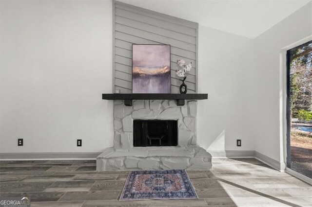 living room with a fireplace, baseboards, and wood finished floors