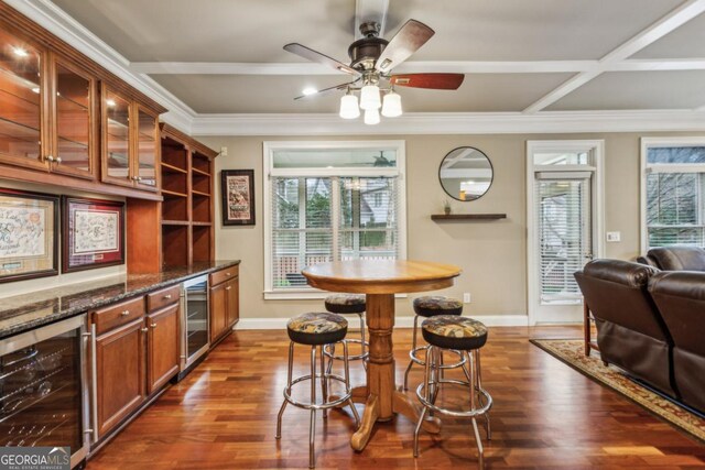 interior space featuring a bar, wine cooler, baseboards, and dark wood-style flooring