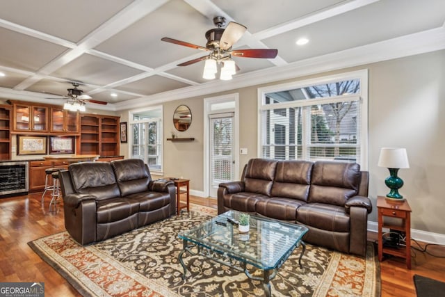 living room with dark wood-style flooring, ornamental molding, beverage cooler, coffered ceiling, and baseboards