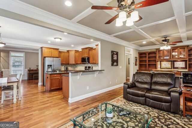 living room featuring light wood-type flooring, coffered ceiling, ceiling fan, and baseboards