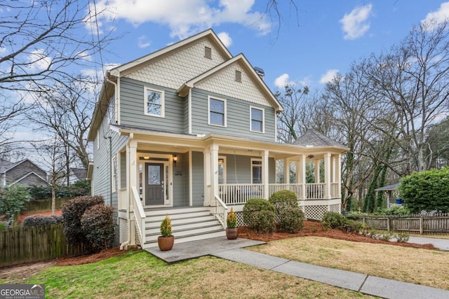 view of front of home featuring a porch, a front yard, and fence