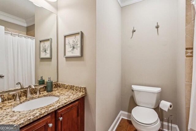 full bath featuring baseboards, toilet, ornamental molding, wood finished floors, and vanity