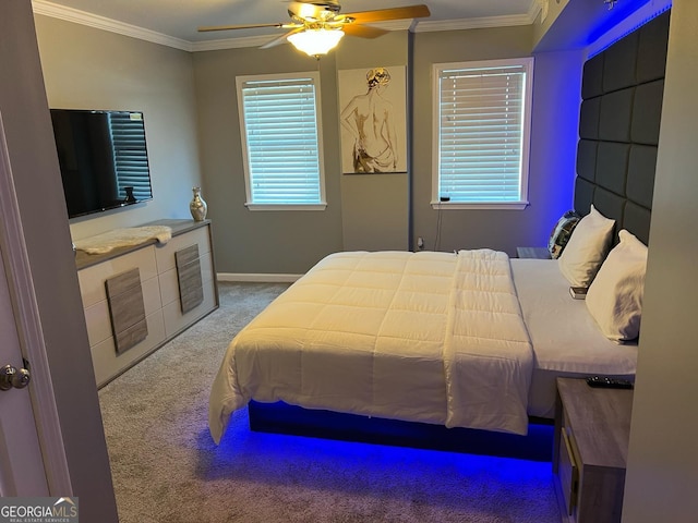 carpeted bedroom featuring a ceiling fan, crown molding, and baseboards